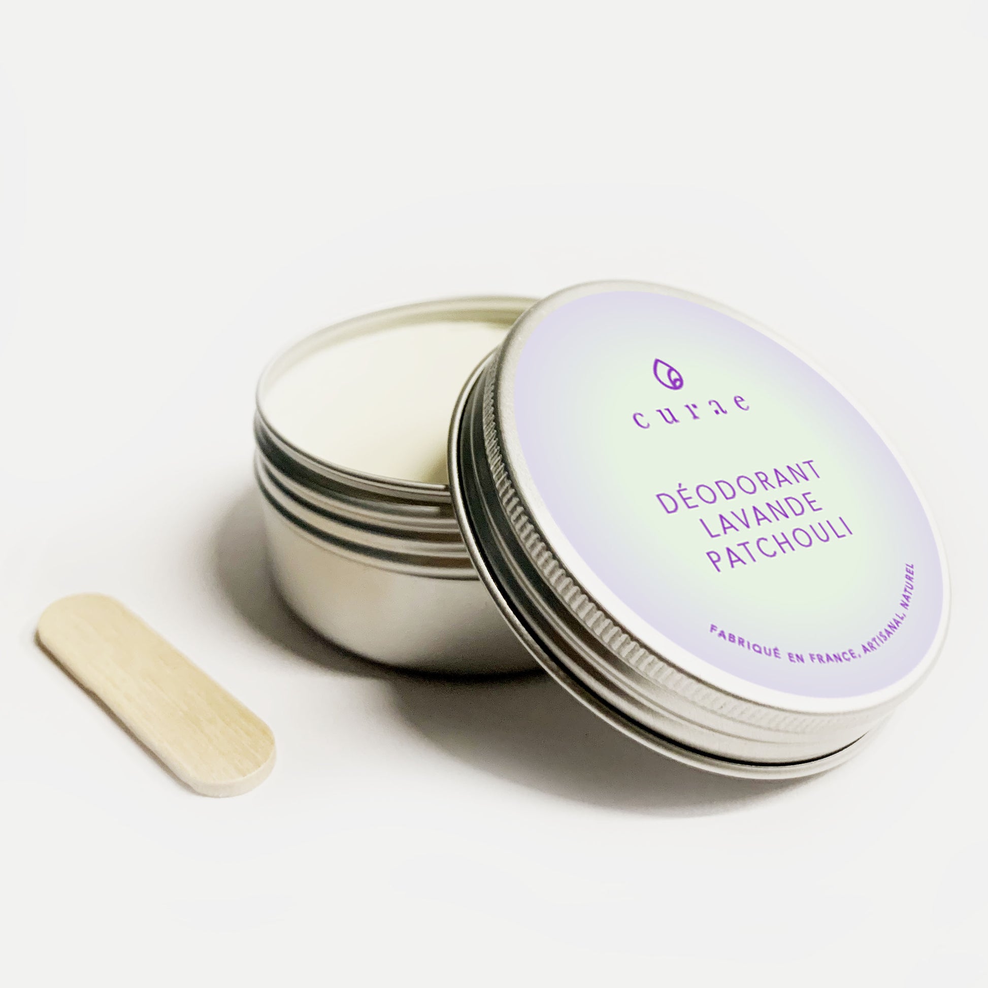 Pot de déodorant ouvert avec une spatule en bois disposé à côté